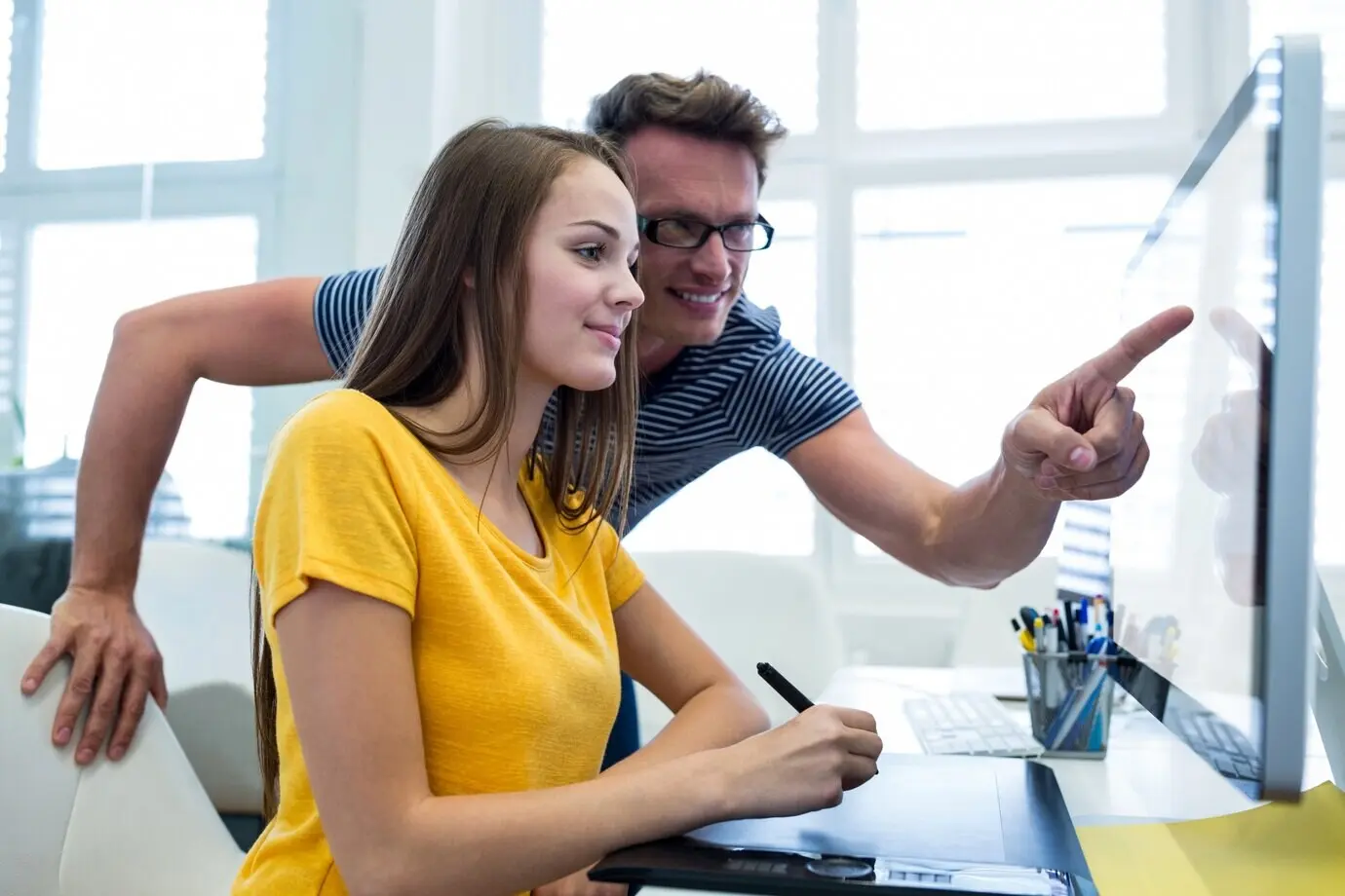 Männliche und weibliche Grafikdesigner verwenden ein Grafiktablett.